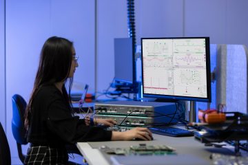 An engineer using the Moku PID Controller and other instruments in a lab setting